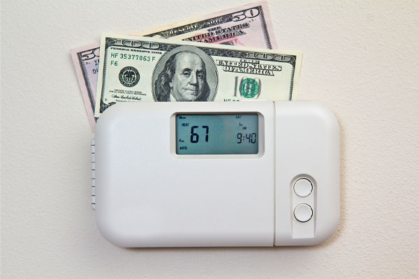 image of thermostat with money depicting home energy costs