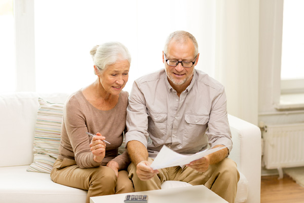 Smiling couple calculating energy savings after an whole home fan install