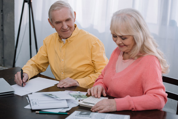 Smiling couple calculating home energy savings after insulation upgrade in home