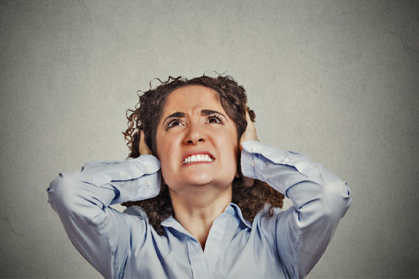 image of homeowner covering ears due to noise and needs soundproofing insulation