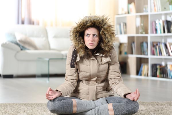image of a homeowner feeling chilly due air drafts in house during winter
