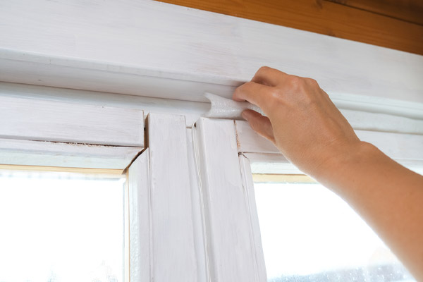 image-of-a-homeowner-air-sealing-home-due-to-window-air-leakage