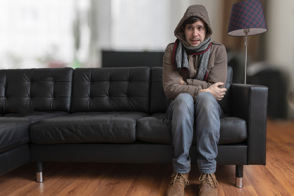 image of a homeowner feeling chilly due to air leaks at home