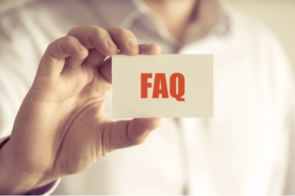 Man holding a mini card that says FAQ depicting Questions About Fiberglass Insulation