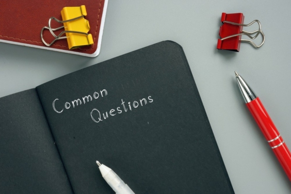 common questions written on a black notebook depicting home insulation FAQs