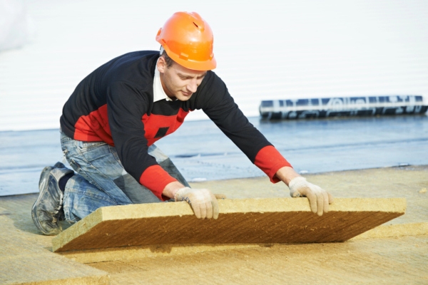 Worker installing roof insulation material