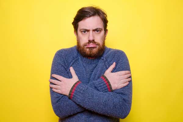 image of a homeowner feeling chilly due to poor insulation