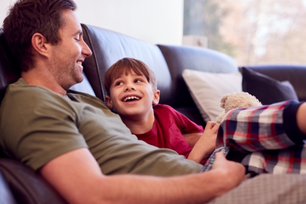 Father and son lounging in the couch depicting good air quality at home