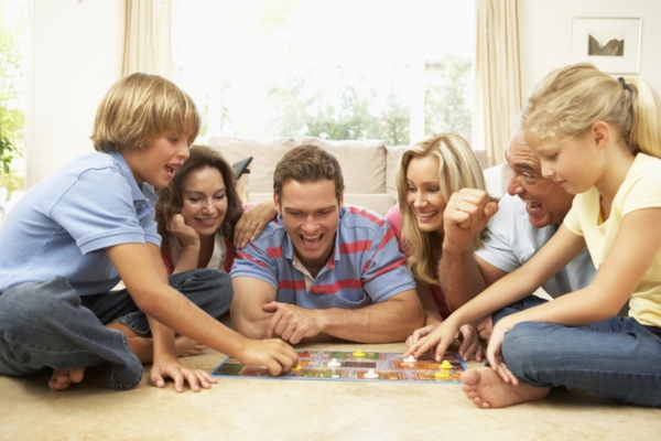 family playing board game staying cool with a whole house fan