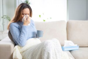 woman on the couch having allergies depicting insulation allergies