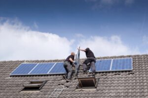 workers installing solar panels on the roof