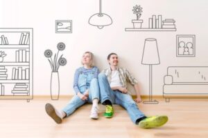 couple sitting on the floor of an empty home imagining progress after installing whole house fan