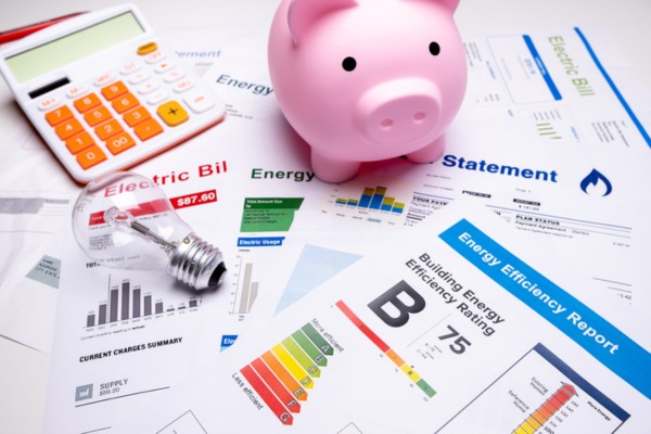 image of utility bills and piggy bank depicting energy savings