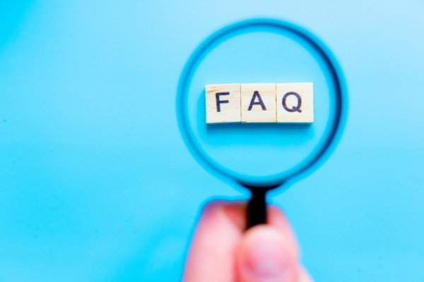 FAQ spelled using small wooden letter chips highlighted by a magnifying glass depicting Questions About Summer Insulation