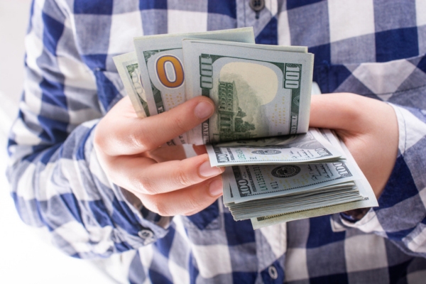 hands holding dollar banknotes depicting financial benefits
