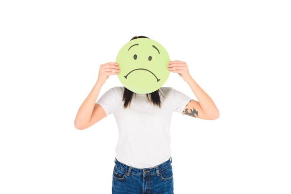woman holding green sign with sad face depicting Common Issues Discovered During Energy Audits