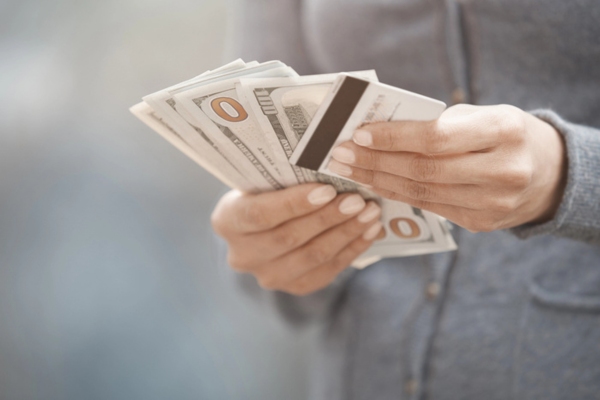 woman holding cash and credit card