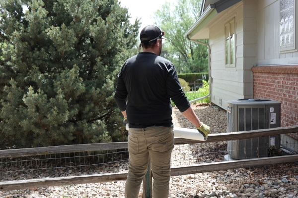 Ascend Construction technician about to examine an air conditioning unit