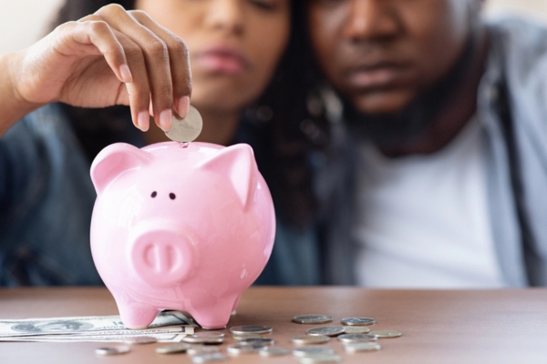 couple putting money in the piggy bank depicting Potential Energy Savings