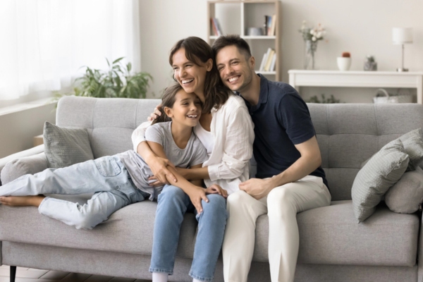 family of 3 lounging on the couch depicting air conditioning safety