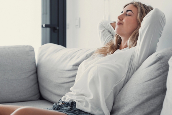 woman relaxing on the couch enjoying new air conditioner