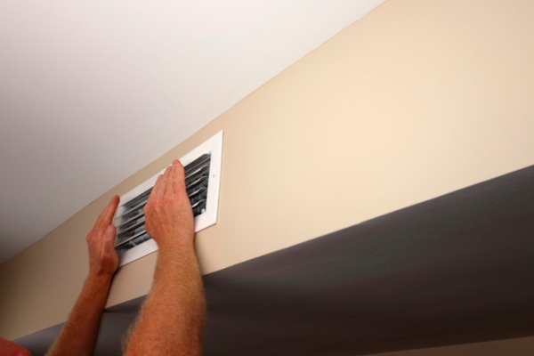 homeowner checking house fan vent